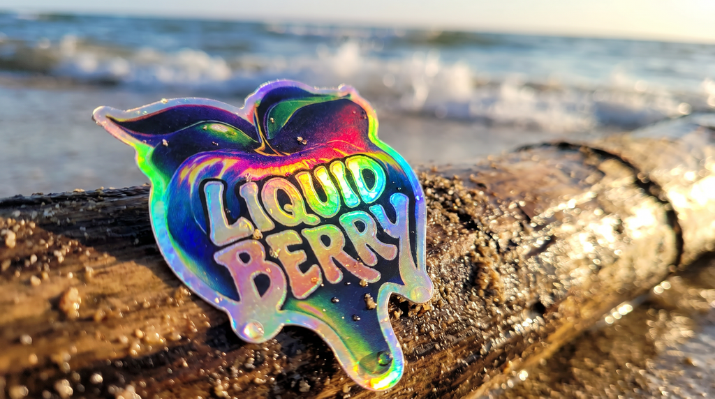 Holographic 'Liquid Berry' logo on a piece of driftwood by the beach